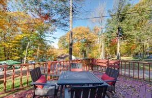 Enjoy dining al fresco on this deck surrounded by lush trees.