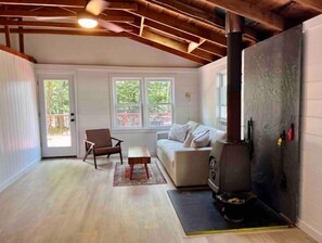 Relax in a warm and inviting space with a fireplace, comfortable seating, and a serene view.