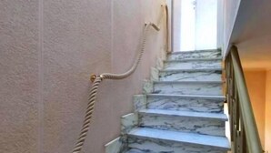 A marble staircase with a rope barrier, leading to a door at the top.