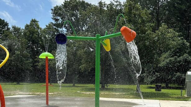 Een speelplaats met water en verschillende kleurrijke waterstralen.