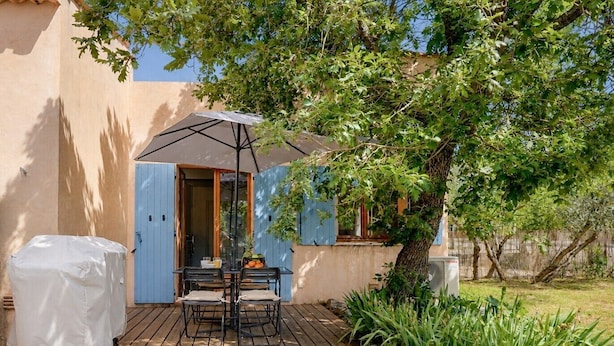 A patio with a table and chairs, a covered umbrella, and a covered object. - Air-conditioned flat for 4 people with garden - Golfe de St-Tropez (Le Plan-de-la-Tour)