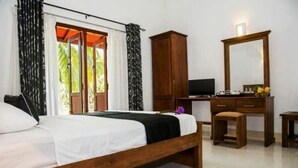 A bedroom with a wooden bed, a desk with a television, and a large mirror. - Coco Villa Peach Tree (Seeduwa - Katunayake)
