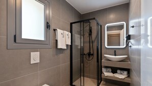 A modern bathroom with a glass-enclosed shower, a white sink, and a toilet. - BRISOT Hotel Galatas Poros (Poros)