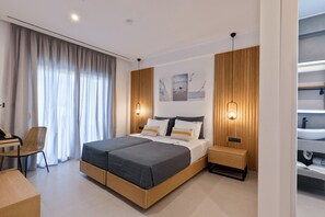 Un dormitorio moderno con cama, mesitas de noche, una silla y vistas al baño.