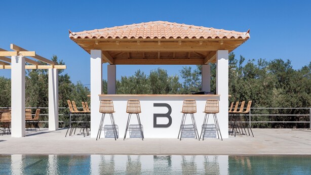 A poolside bar with a tiled roof and white pillars, surrounded by lounge chairs. - BRISOT Hotel Galatas Poros (Poros)