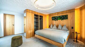 Un dormitorio moderno con cama suspendida, paredes de madera y una lámpara en el techo.