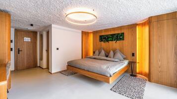 A modern bedroom with a floating bed, wooden walls, and a ceiling light fixture.