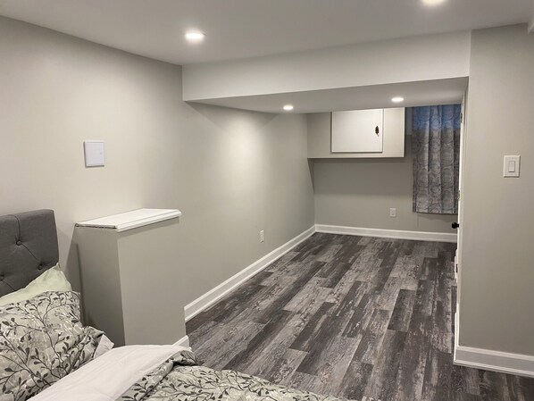 Cozy retreat with a bed, bedside table, and wall-mounted cabinet, perfect for a restful stay.