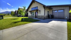 A two-story house with a garage, a driveway, and a small lawn. - Upscale Mountain Retreat (Red Lodge)