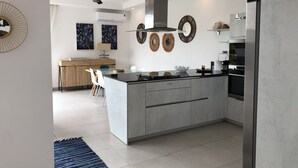 A modern kitchen with a central island, built-in appliances, and decorative wall art.