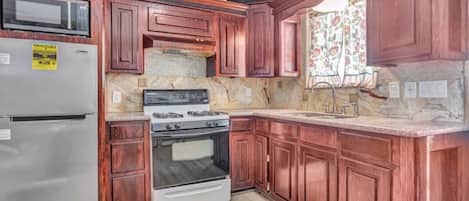 Kjøleskap, mikrobølgeovn, kjøkkenutstyr og papirhåndklær