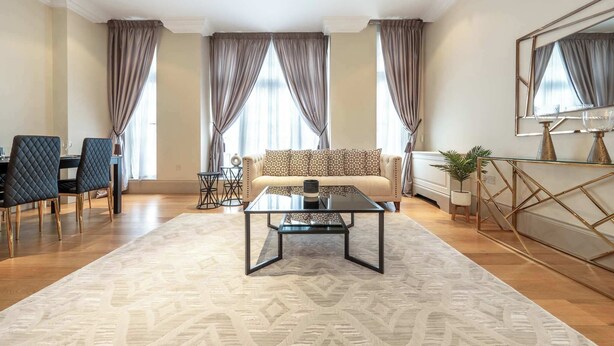 Een moderne woonkamer met een bank, salontafel en een eethoek.