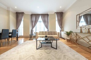 Een moderne woonkamer met een bank, salontafel en een eethoek.