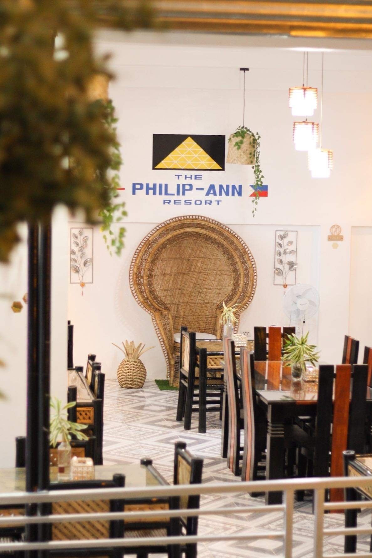 Ein Essbereich im Philip-Ann Resort mit einer großen gewebten Wanddekoration, hängenden Lampen und einer Ananas-Dekoration.