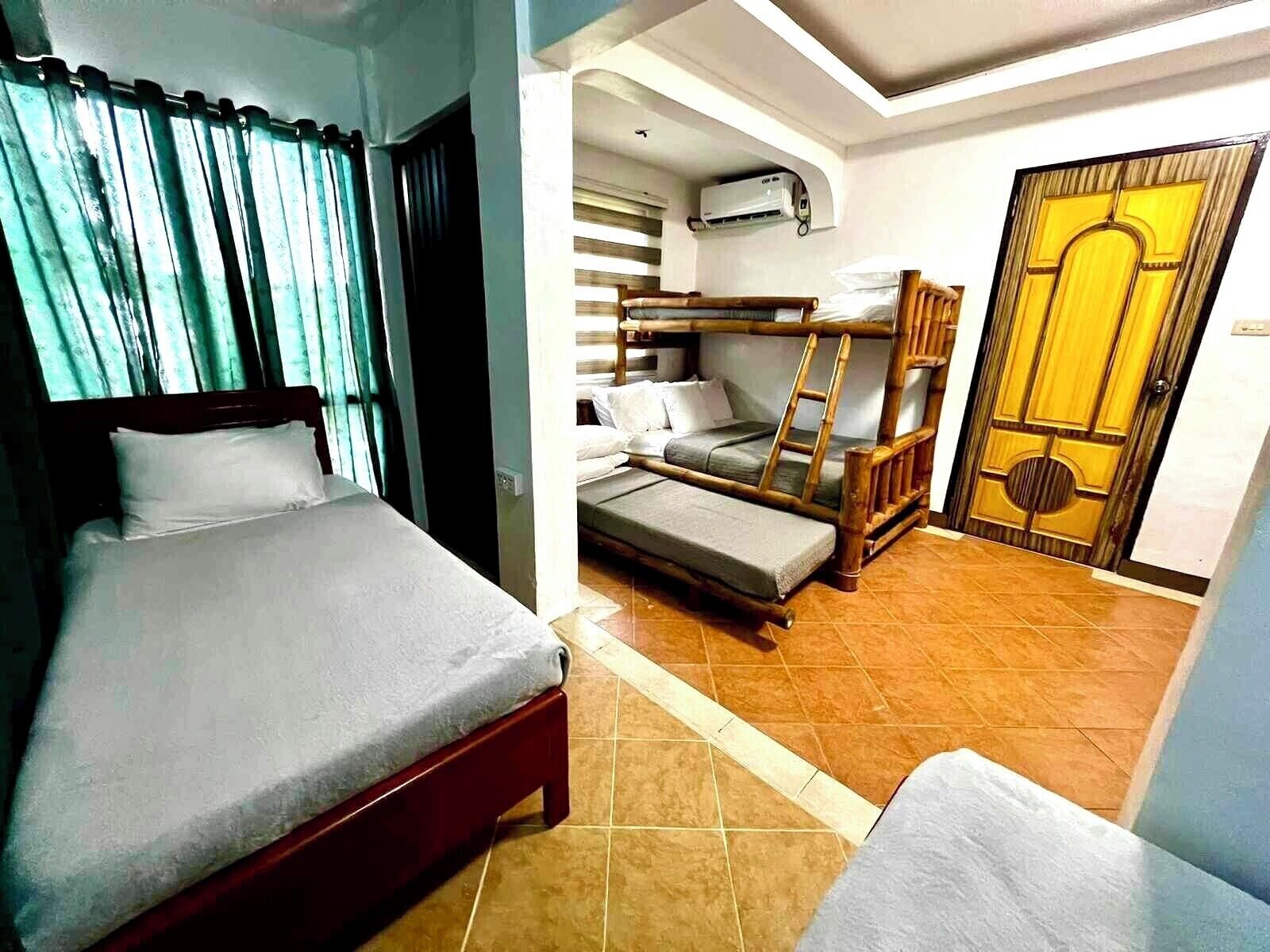 A room with a single bed, a bunk bed, and a door with a decorative design.