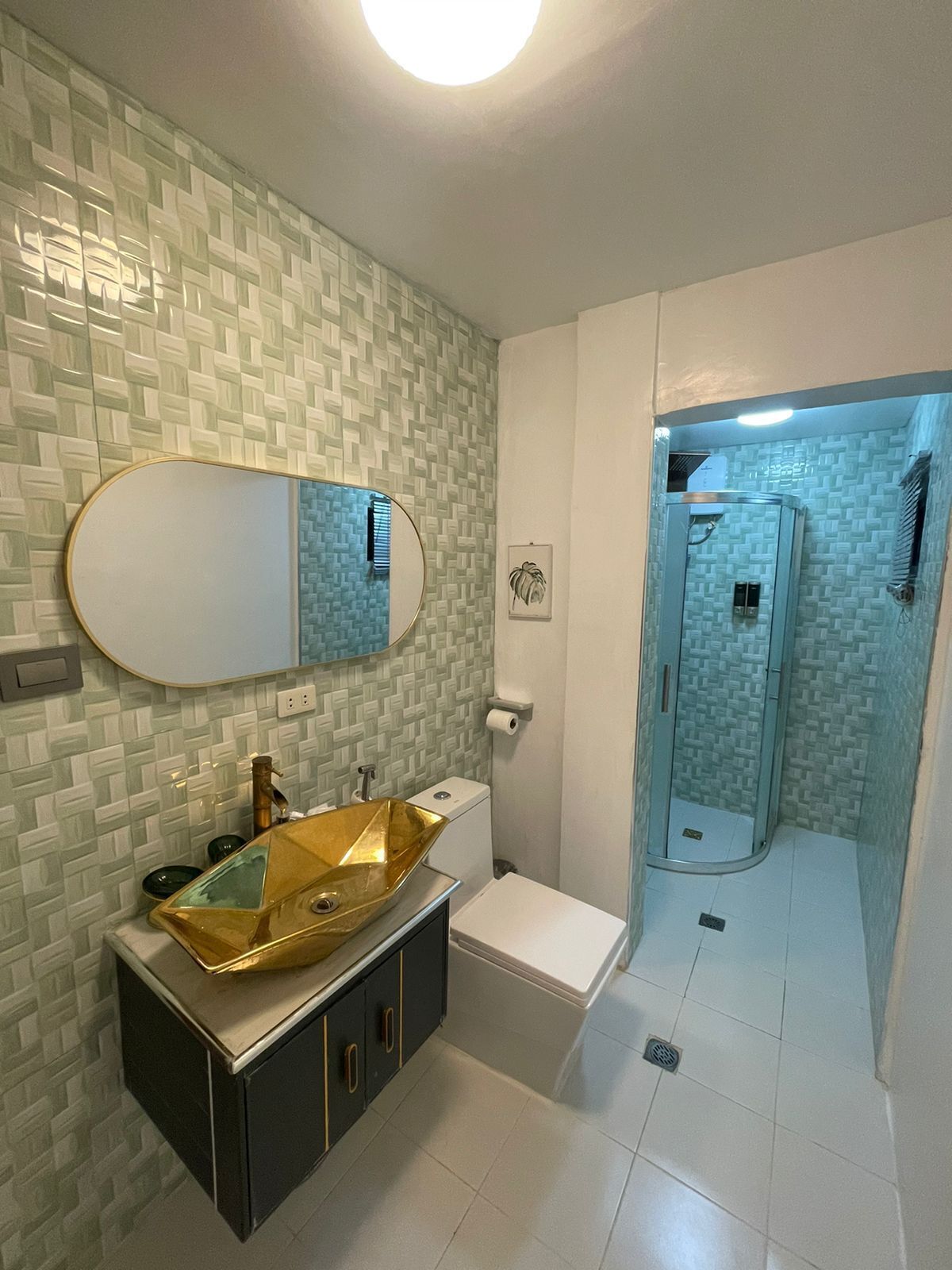 A bathroom with a gold sink, white toilet, and a shower with a glass door.