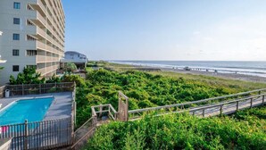 Un hôtel doté d’une piscine, offrant une vue sur la plage et disposant d’un sentier menant à la plage.