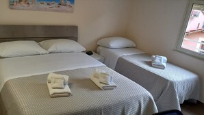 A hotel room with a large bed, two bedside tables, and a window. - B&B Omnia Scilla (Scilla)