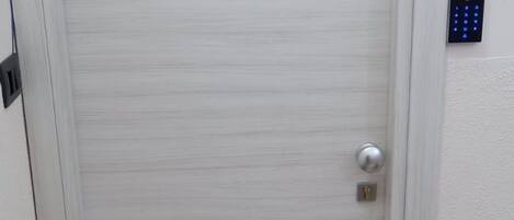 A white door with a keypad lock and a number '5' on it.