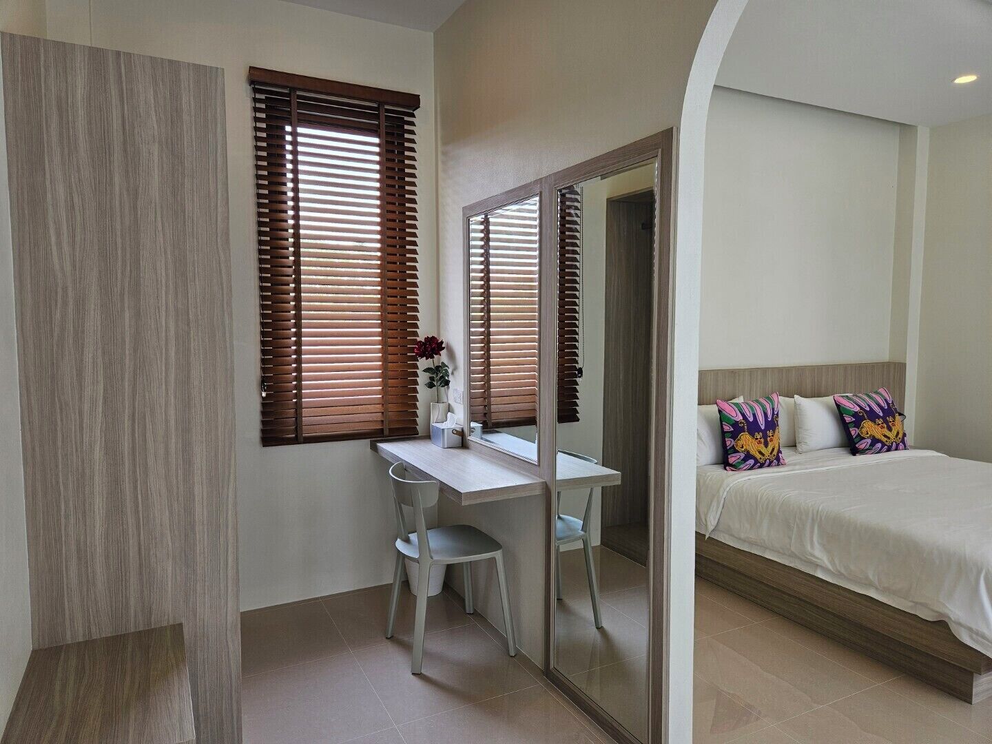 A bedroom with a bed, a desk, and a chair.