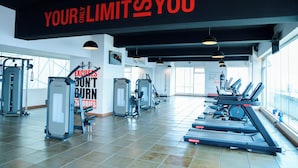 Ein Fitnessstudio mit Trainingsgeräten, motivierenden Plakaten und großen Fenstern.