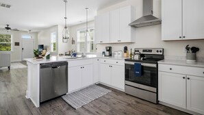 Een moderne keuken met witte kasten, roestvrijstalen apparatuur en een centraal eiland.