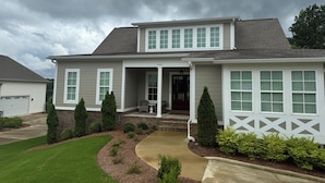 A two-story house with a front porch, a garage, and a well-maintained lawn. - Oasis in Oxford - 4BR with an amazing view (Oxford)