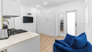 A modern kitchen with a gas stove, a kettle, and a flat-screen TV mounted above the counter. - Hot Location-New Studio for 2-Beach-Margaritaville (Hollywood)