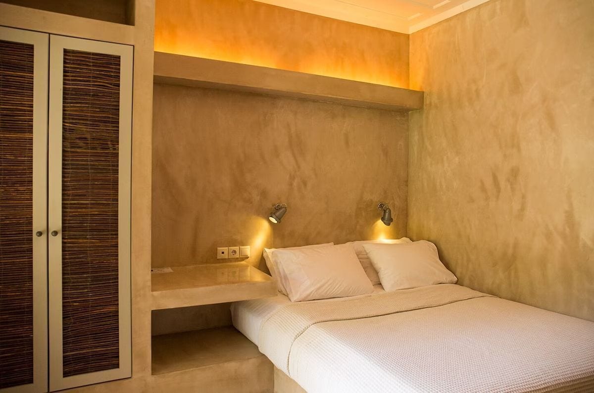 A bedroom with a bed, a nightstand, and a wardrobe.