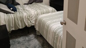 Ein Schlafzimmer mit zwei Betten, einem Fernseher und einer Tür.