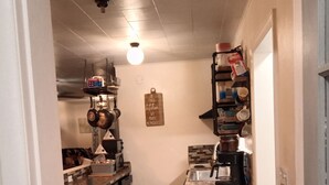 Une cuisine dotée d’un îlot central, d’un porte-ustensiles suspendu et d’une machine à café.