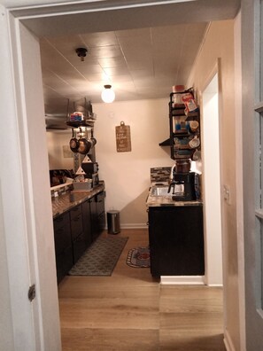 Cuina amb una illa central, un penjador per a gots i una màquina de cafè.