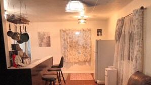 Ein Wohnzimmer mit einer Ledersofa, einem Couchtisch und einem Essbereich mit einer Bar.