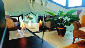 A modern living room with a glass coffee table, two sofas, a potted plant, and a fireplace. - Hilltop Luxury Villa with Minigolf, Indoor Pool, Wellness & Spa (Oberbütschel)