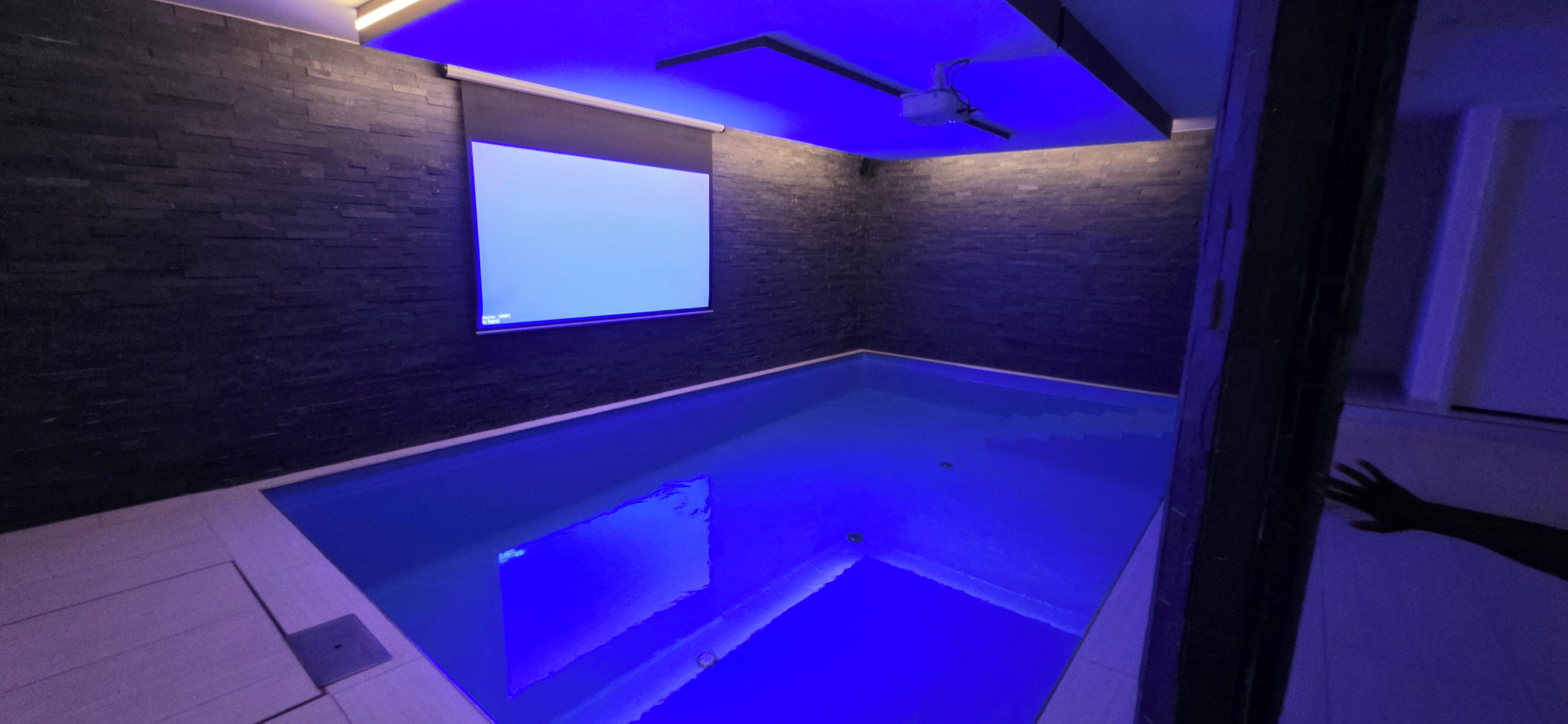 Une pièce dotée d’une baignoire intégrée, d’une fenêtre et d’un ventilateur de plafond.