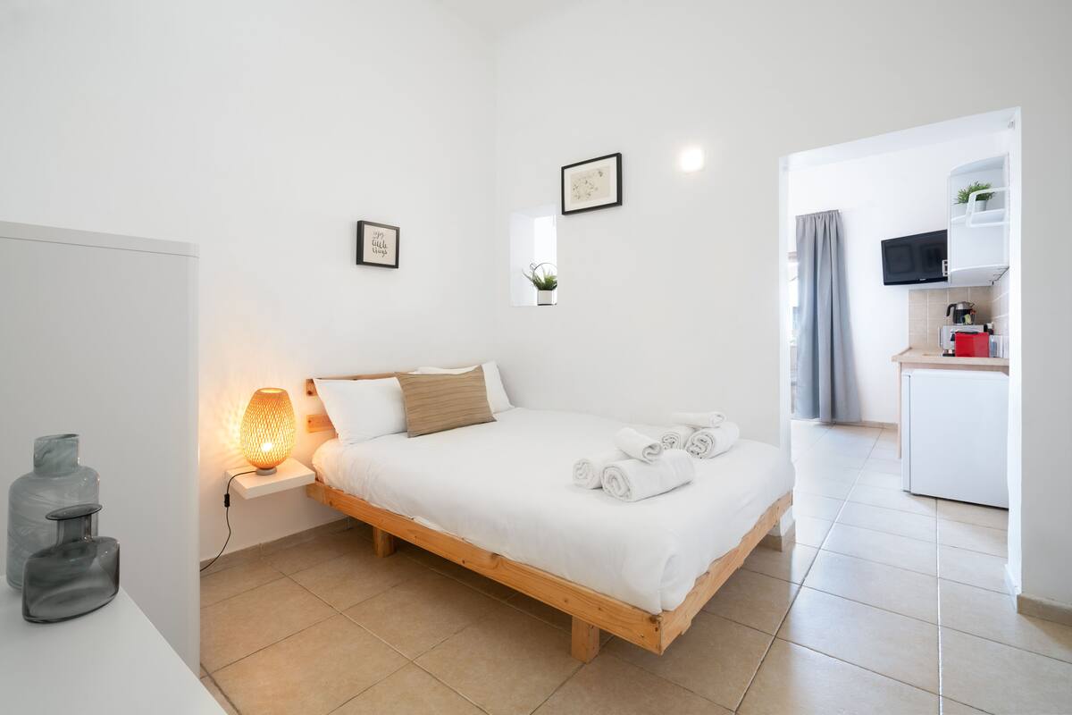 Une chambre à coucher moderne avec un lit en bois, une lampe de chevet et une petite table de chevet.