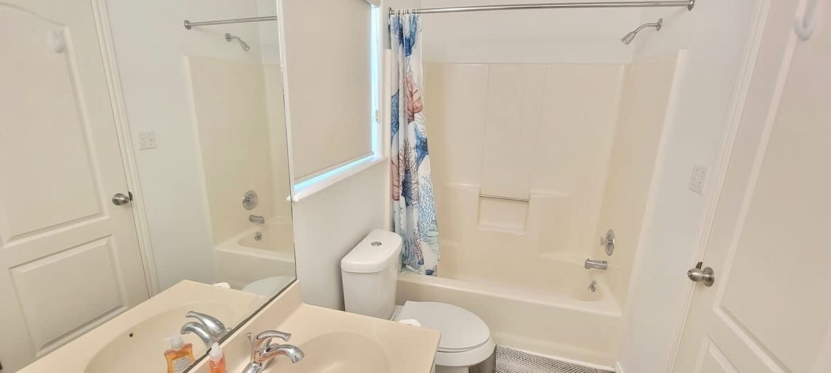 A bathroom with a bathtub, toilet, and sink.