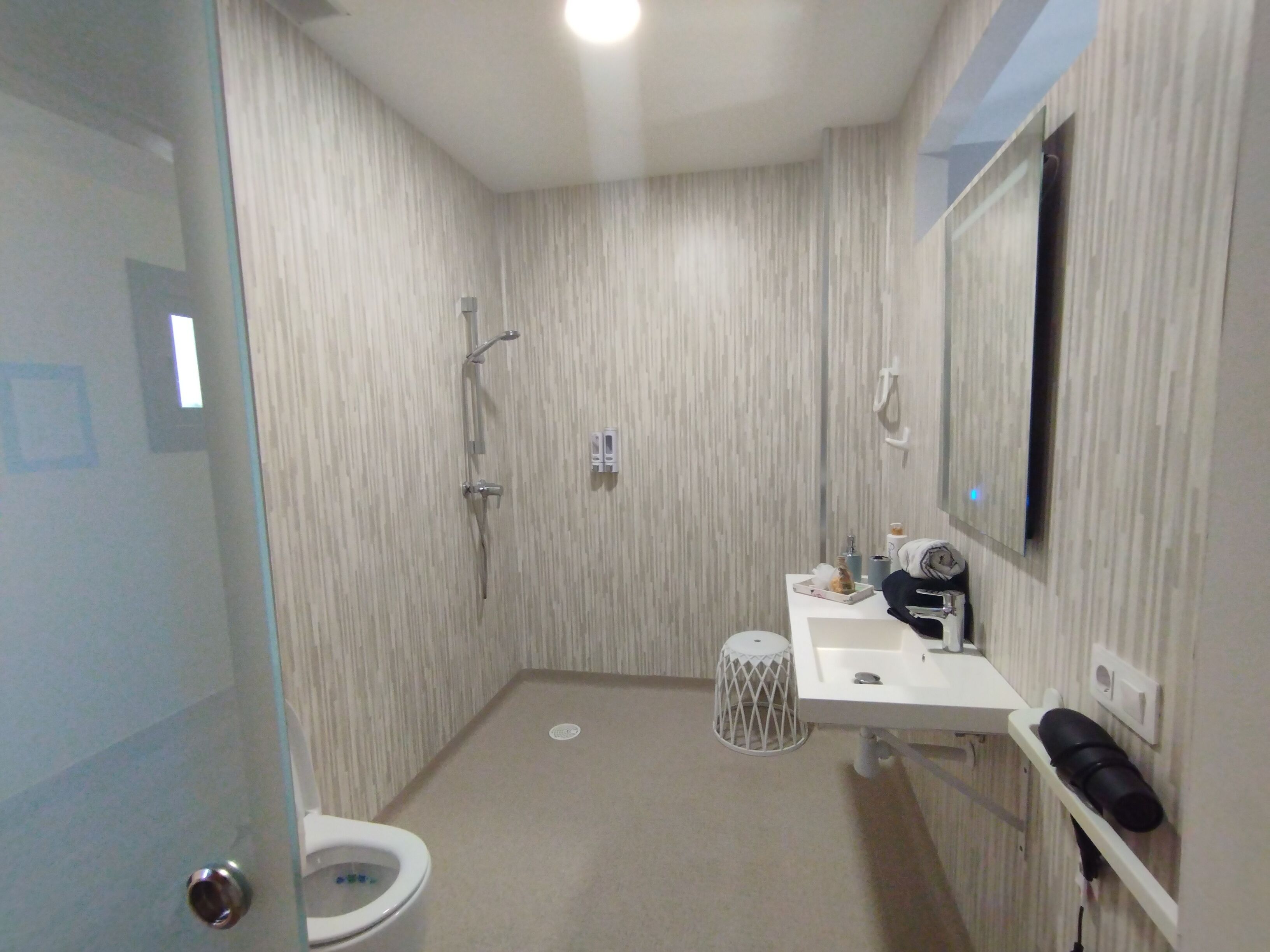Un bagno con WC, lavandino, specchio e doccia.
