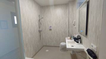 Un bagno con WC, lavandino, specchio e doccia.