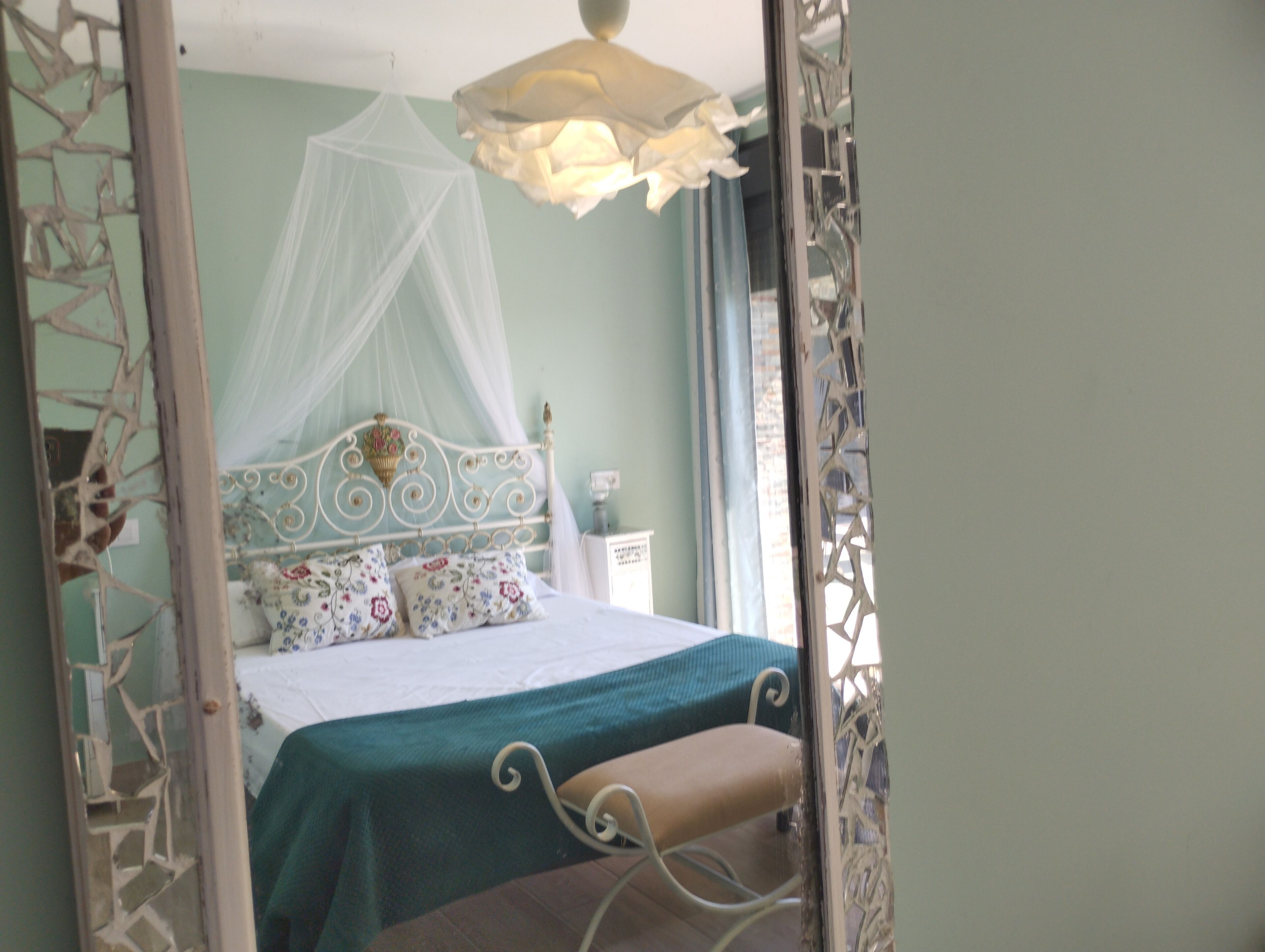 A bed with a canopy, a bedside table, and a nightstand.