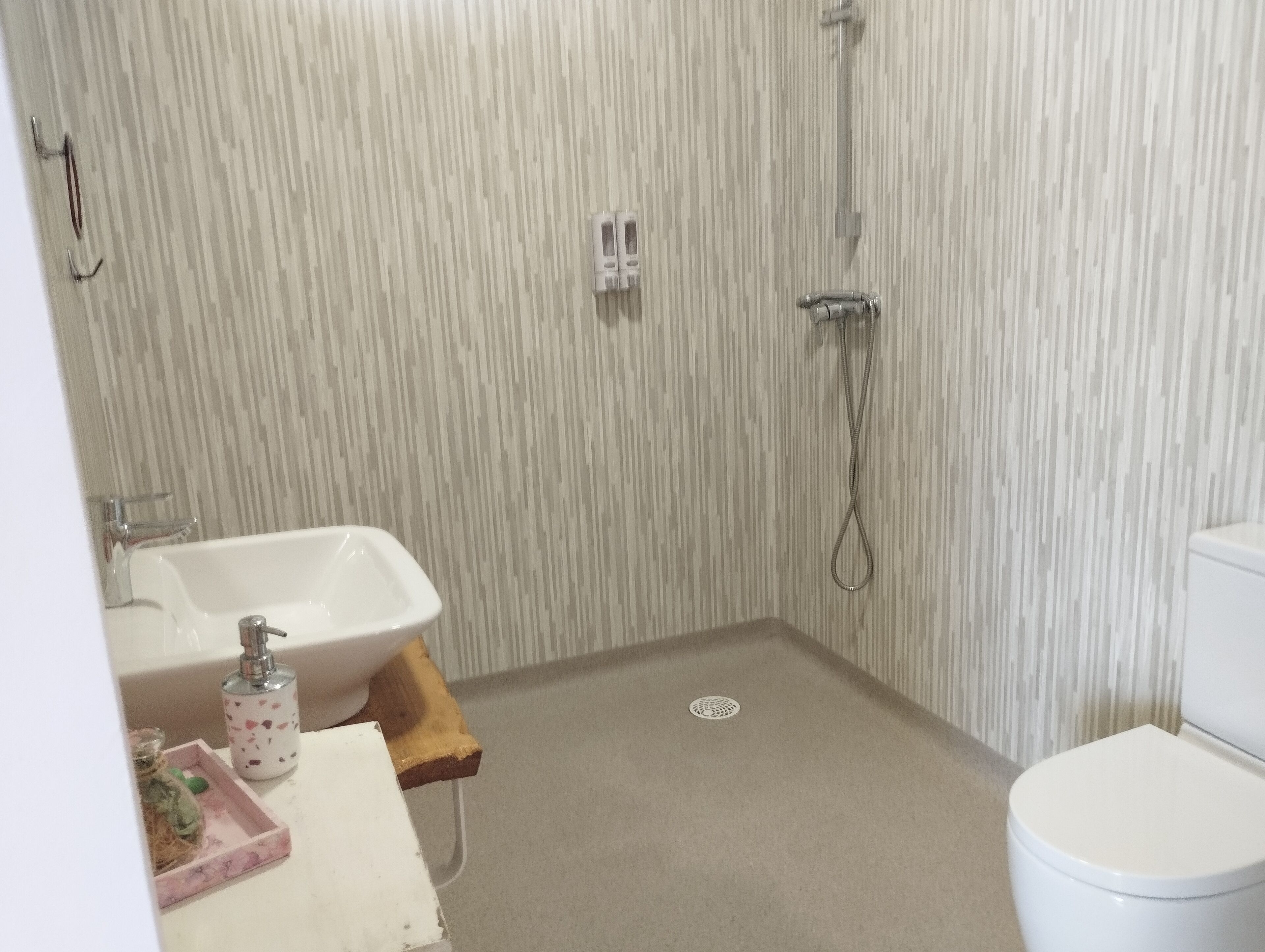 Une petite salle de bain avec une douche, un lavabo et des toilettes.