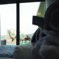 Una cama con vista a un comedor y un árbol fuera.