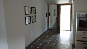 Un pasillo con suelo de baldosas y cuatro cuadros en la pared.
