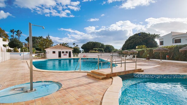 A swimming pool with a lifeguard tower, a small pavilion, and a covered seating area. - Casa da Praia with pool area
 (Porches)