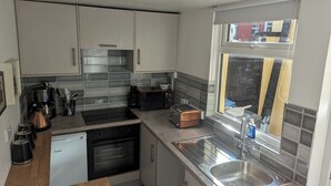 A modern kitchen with stainless steel appliances, a built-in oven, and a window with a view of the outside. - Fantastic Location to Ebrington Sq and City Centre (Londonderry)