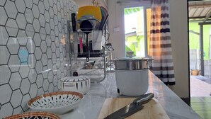 A kitchen with a hexagonal tile backsplash, a wooden countertop, and a large cutting board. - Getaway near Patong Beach, shops and restaurants. Homey, private, and memorable. (Tambon Patong)