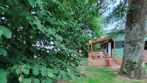 A wooden pergola in a garden with a staircase leading to a building. - La Tiny de Papy (Attignat)