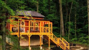 Eine Holzhütte mit einem Balkon und einer Treppe zu einer Terrasse.