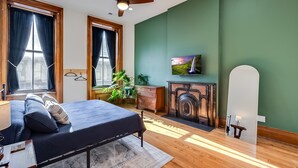 A bedroom with a bed, a dresser, a mirror, a fireplace, and a television. - The Selbert - In the Heart of The Bourbon Trail! (Frankfort)