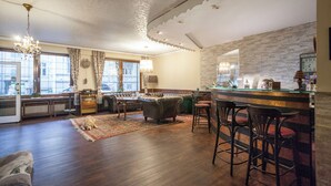 A cozy living room with a fireplace, a dining area, and a bar with stools. - Union Hotel by TM (Dortmund)